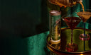 Teaspressa Espresso Martini Luxe Mixer Cube on a gold tray beside two Espresso Martinis, set against green velvet