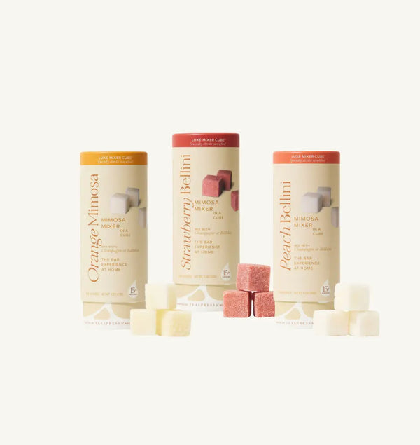 Orange Mimosa, Strawberry Bellini, and Peach Bellini Mimosa Mixer Tallboys in cream cylindical packaging with 3 cube trios. 